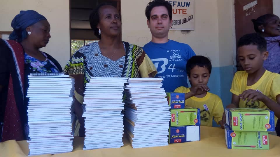 Volontari che distribuiscono materiale scolastico: penne e libri e quaderni